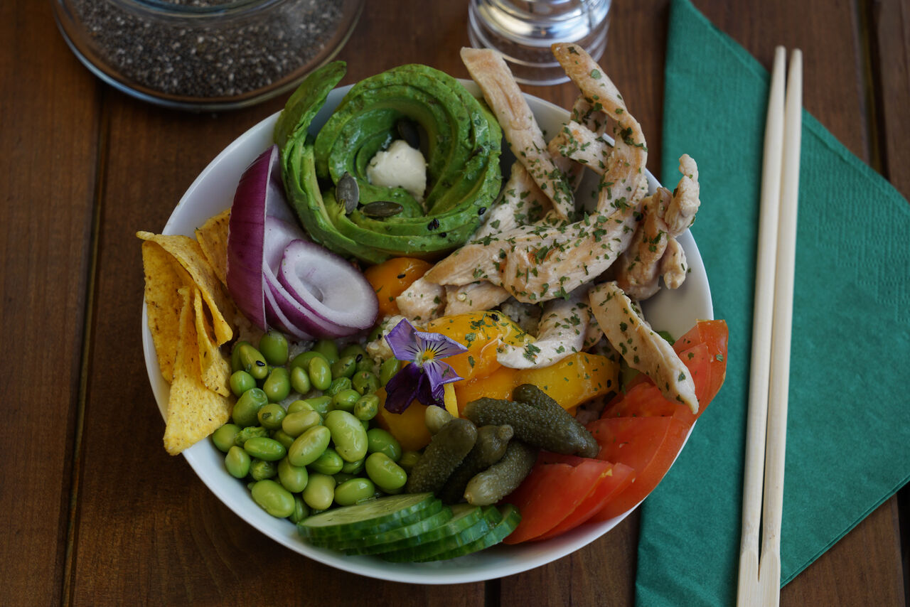 Grilled Chicken : Poke Bowl met gegrilde kip , avocado, edamame, komkommer, mango, nachos, ui, auguren, kaas en saus