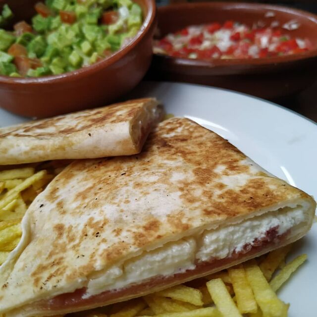 Quesadilla de jamón serrano y 4 quesos.(Servida con guacamole y pico de gallo caseros). 