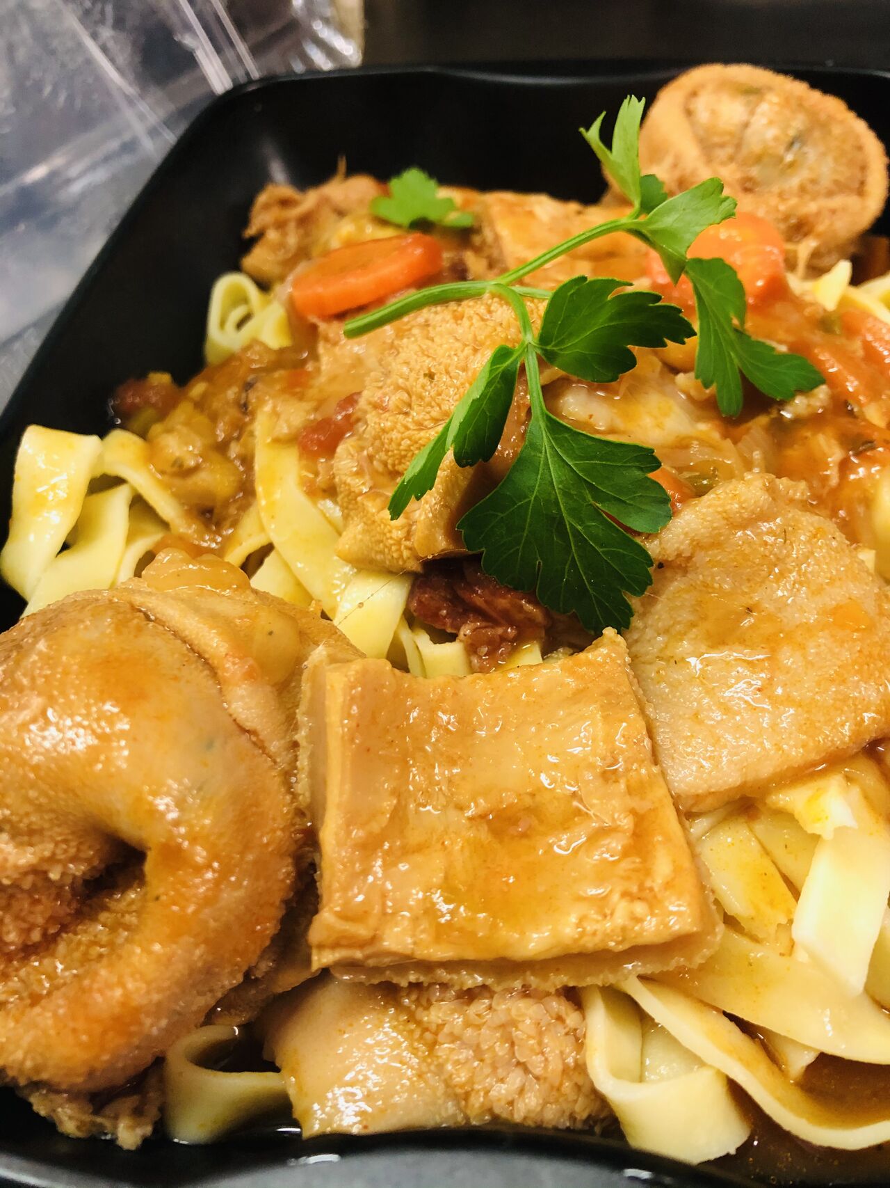 Duo de paquets d’agneau et tripes à la tomate sur lit de pâtes fraîches.