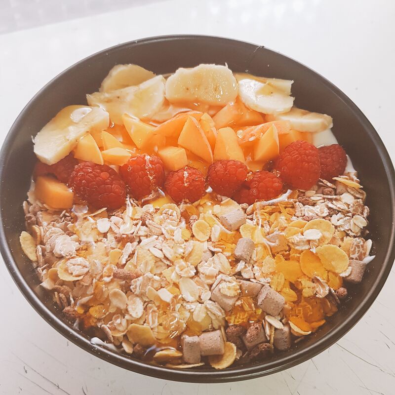 Desayunos saludables.Bowl de yogur natural con muesli y fruta de temporada.