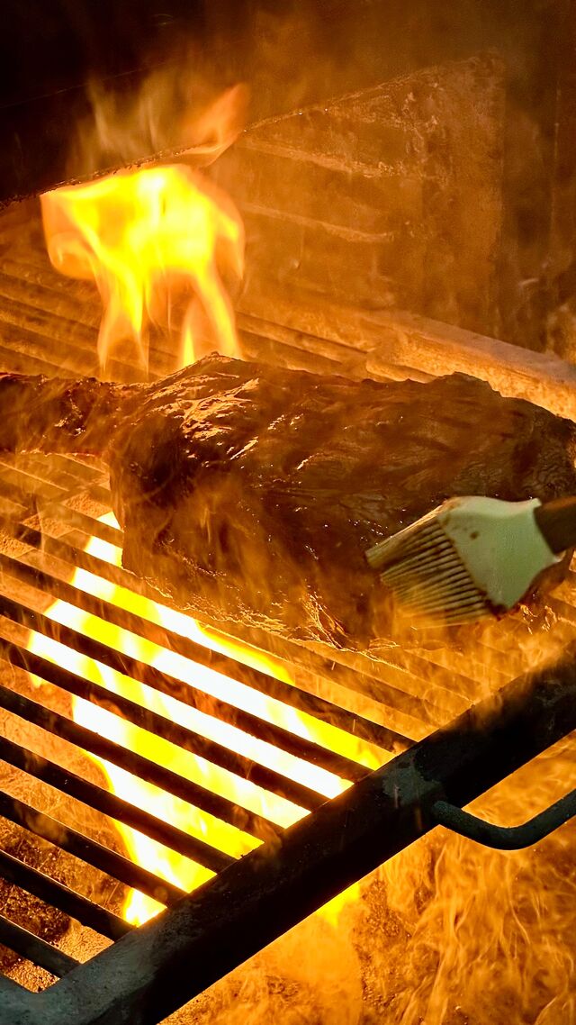 Dry aged beef tomahawk cooked on open fire grill