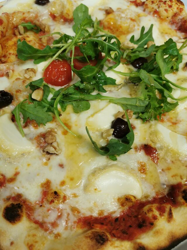 Maya : Sauce tomate, mozzarella, chèvre, miel, noix, roquette. 