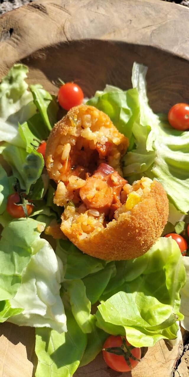 Les arancinis. Spécialité sicilienne composée d'une boule de riz safrané aux poivrons farcie au poulpe et à la tomate