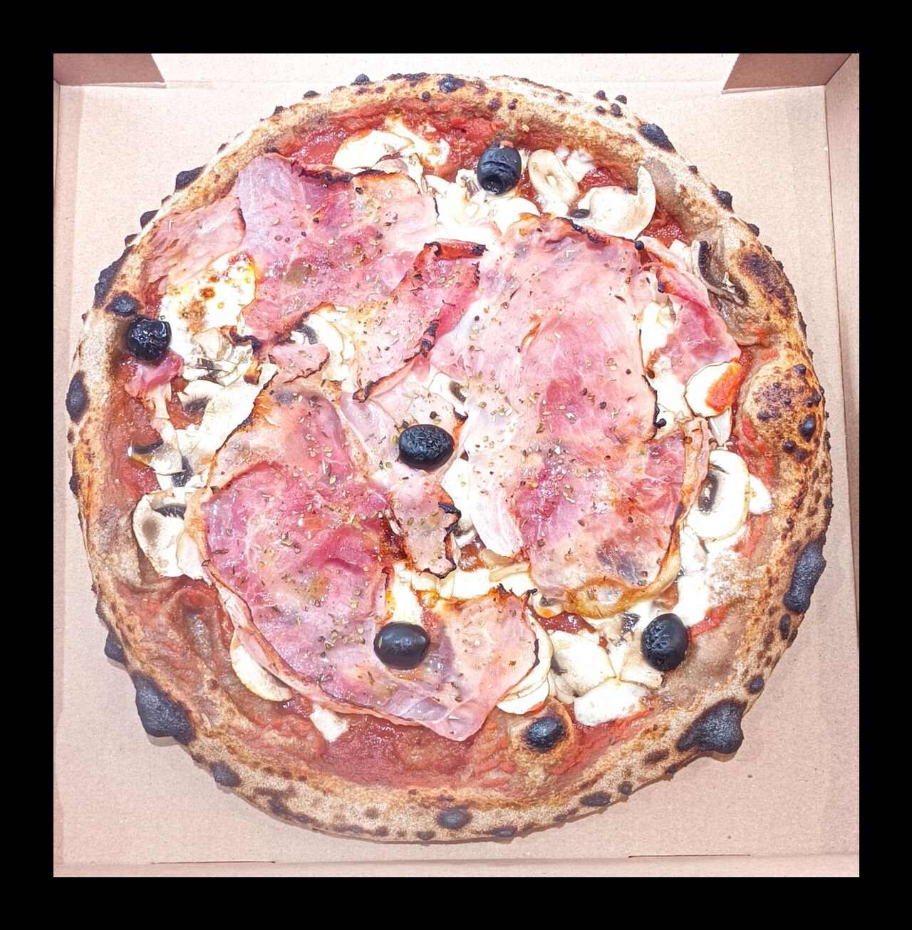 Pizza Regina - Base tomate, mozza FDL, champignons, jambon blanc, origan, olives noires, filet huile olive
