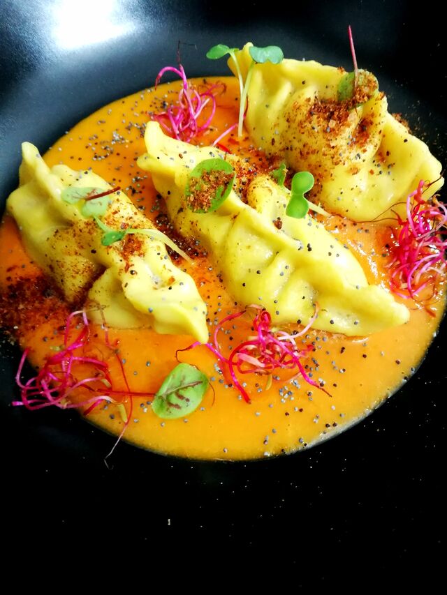 Ravioli ripieni di baccalà e patate con pomodorini Nduja germogli e polvere di gambero rosso 