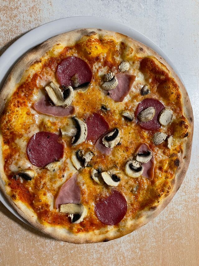 Pizza Mista, mit Salami, gekochtem Schinken und frischen Champignons.