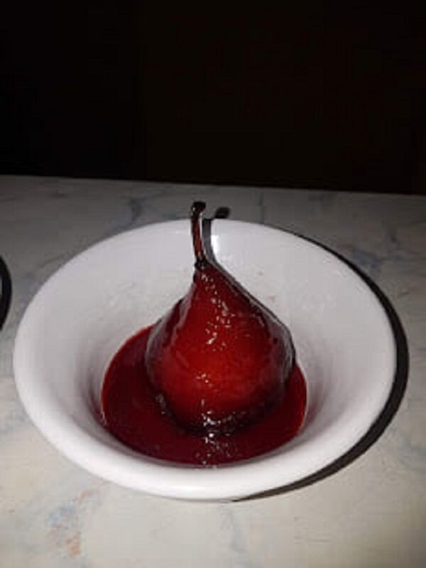 Poire cuite au vin rouge service à l'assiette 