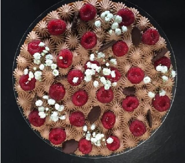 La Surprenante : Croustillant aux noisettes, Crémeux chocolat lait et framboises, Fleurs chocolat noir, Framboises avec coulis