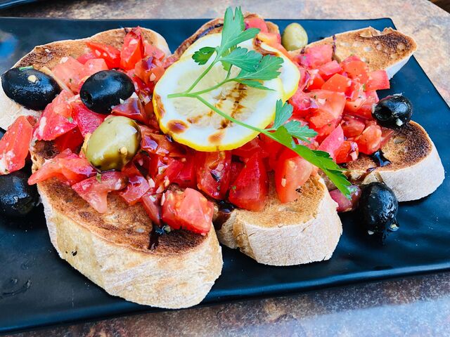 Bruschetta. Tomatenwürfel fein gewürzt mit Oliven und frischen Kräutern auf knackig geröstetem Ciabatta