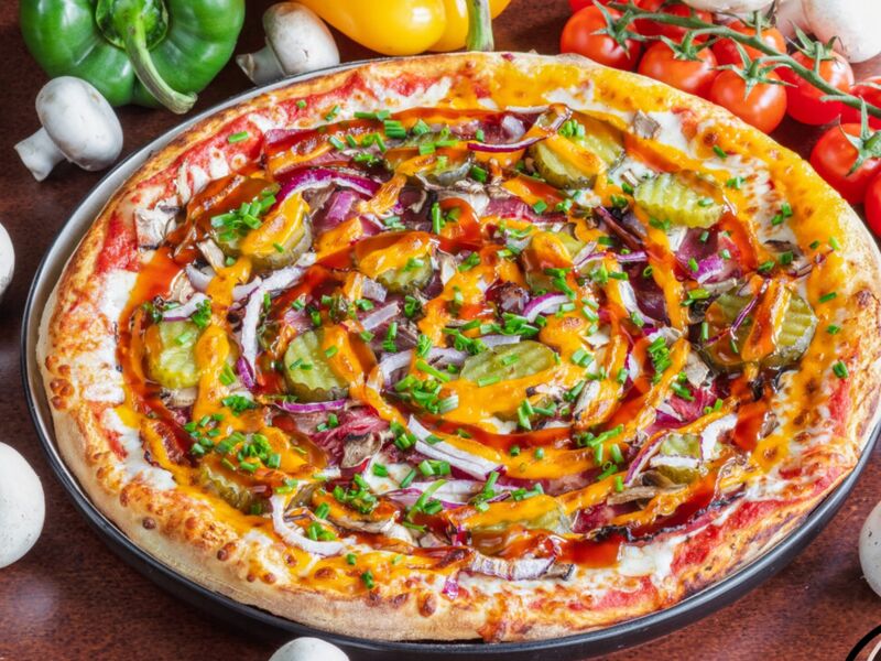 Pizza Riga,
Sauce tomate, fromage cheddar, bacon, cornichons doux, champignons, oignons rouge, mozzarella, ciboulette, sauce BBQ