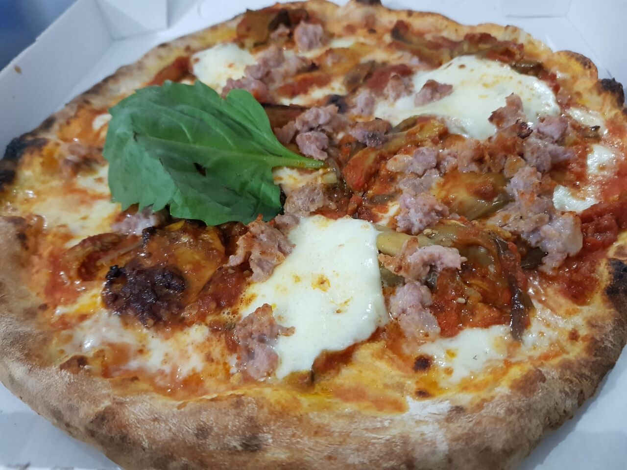 La pizza parmigiana di melanzane e salsiccia