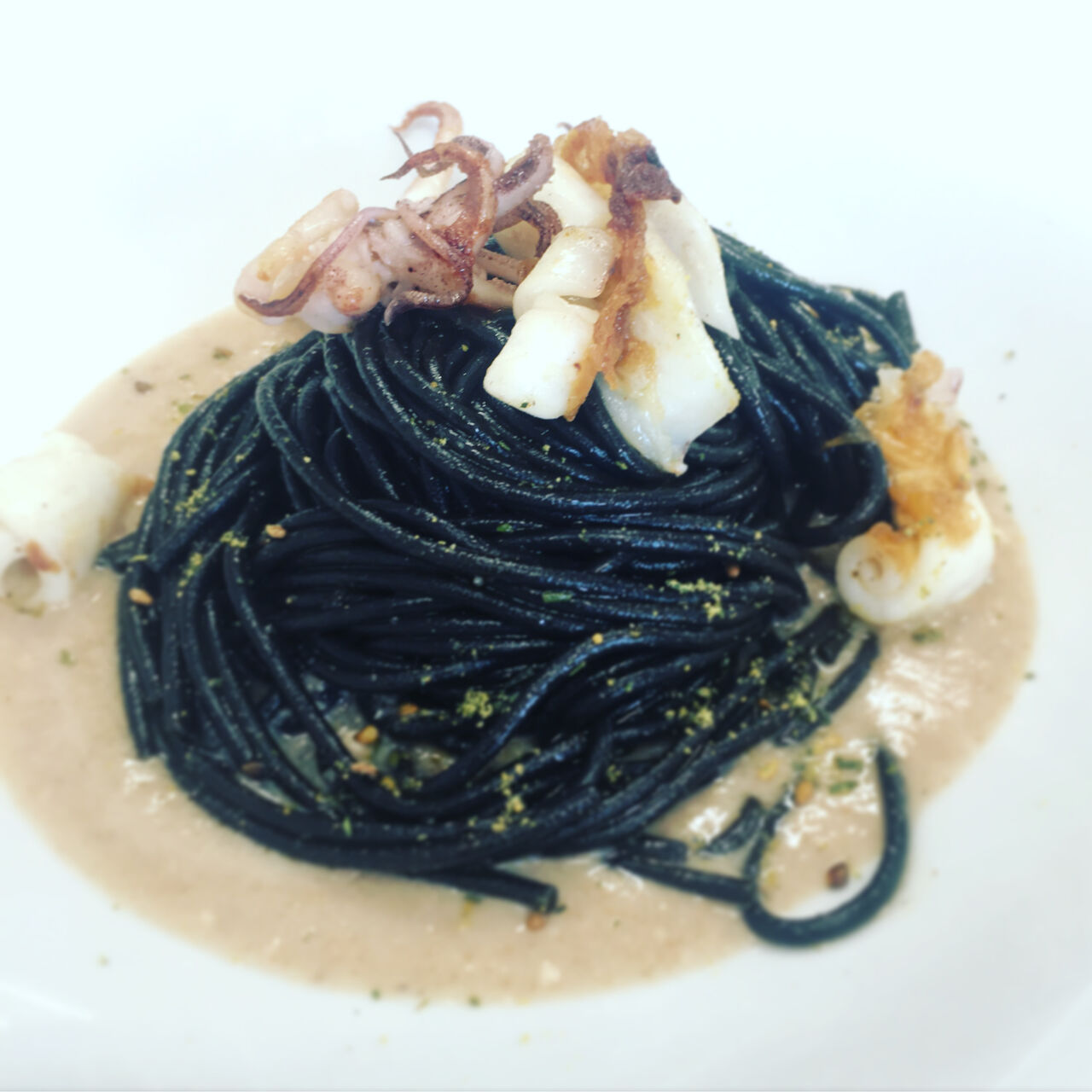Spaghetti al nero con seppie alla piastra su crema ai 18 cereali