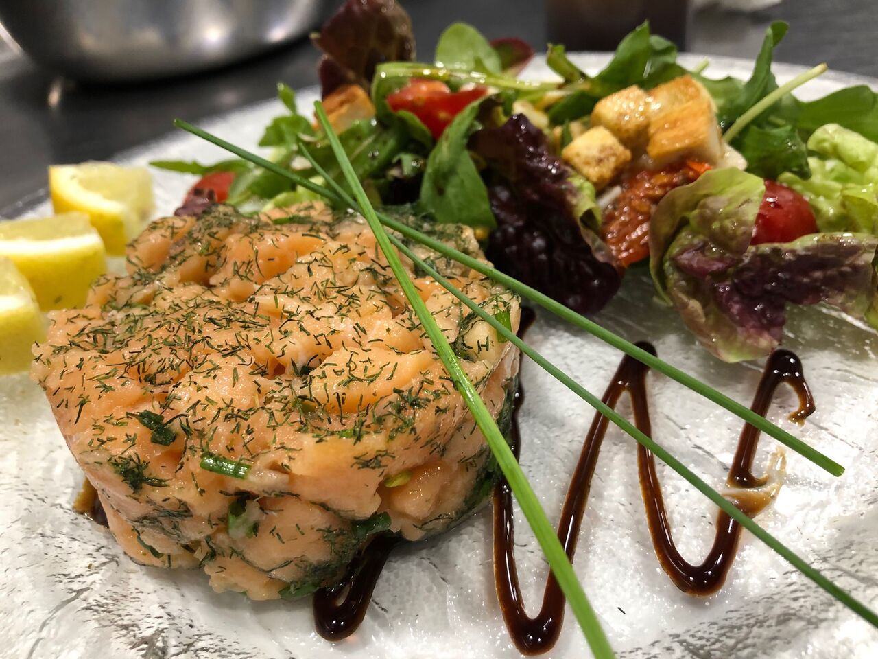 TARTARE DE SAUMON MARINE : mariné (huile d'olive, citron, ciboulette, échalote), avec salade, tomates cerises et confites