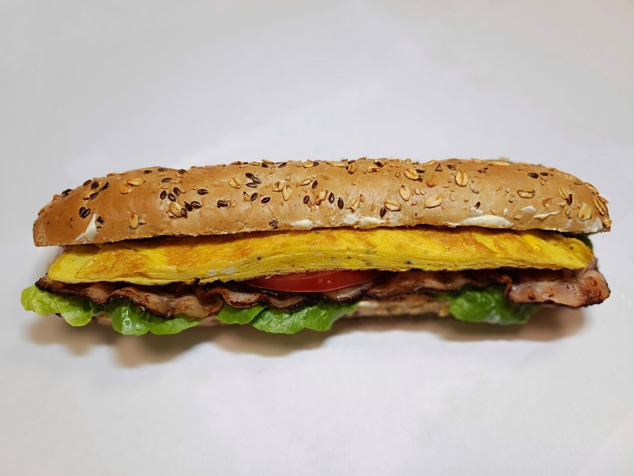 cereální snídaňová bageta s vaječnou omeletou a vyškvařenou slaninou