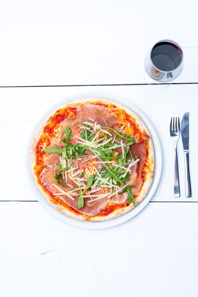 Pizza Parma mit einem leckeren Rotwein