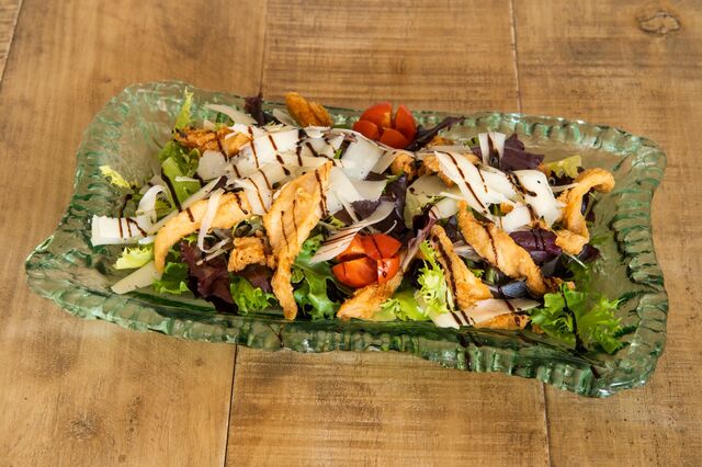 Ensalada César con pollo crujiente y salsa tártara con queso parmesano.