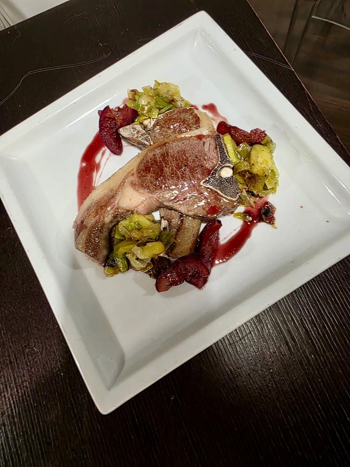 Costolette d'agnello con porri, prugne glassate al vino rosso 