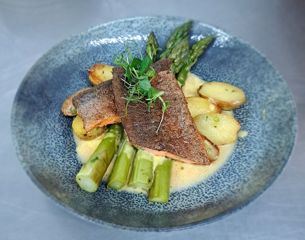 Gebratenes Lachsforellenfilet mit grünem Spargel, Zitronen-Buttersauce und Gourmeterdäpfel