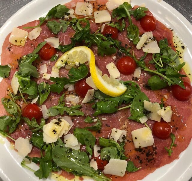 CARPACCIO DE BŒUF BLACK ANGUS : huile d'olive, roquette, tomates cerises, citron, parmesan, accompagné de ses frites