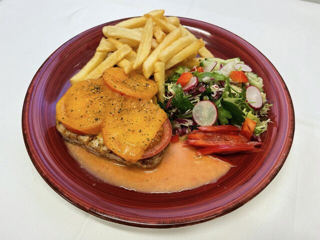 Schweinesteak mit Tomate und Käse überbacken an Pommes und Salat 