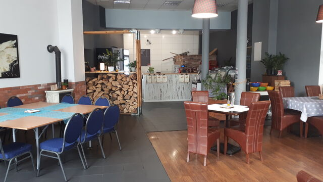 Nasz lokal w środku, stoliki z miejscami indywidulanymi, a w tle za barem nasz piec do pizzy (i nie tylko) opalany drewnem.