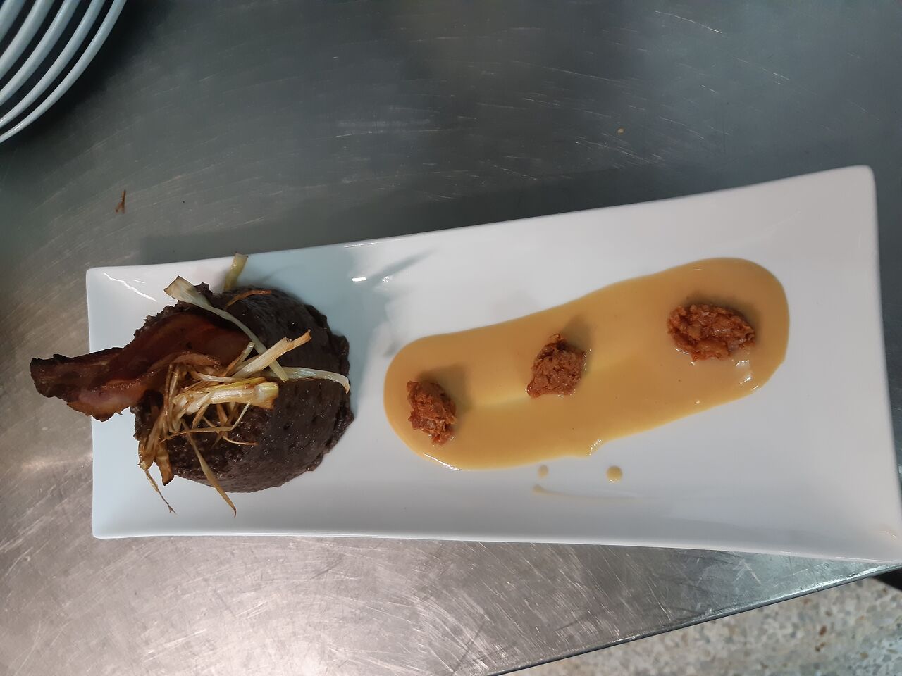 Pastel de morcilla con crema de alubia blanca y teja de bacon