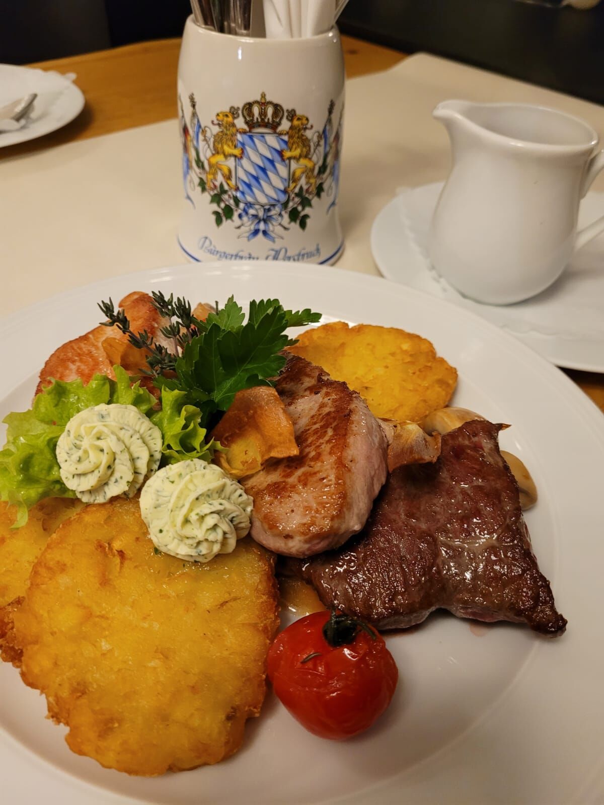 Brauhausteller (Rind/ Kalb/ Pute) auf gebratenen Dunkelbierchampignons, mit Rösti, Kräuterbutter