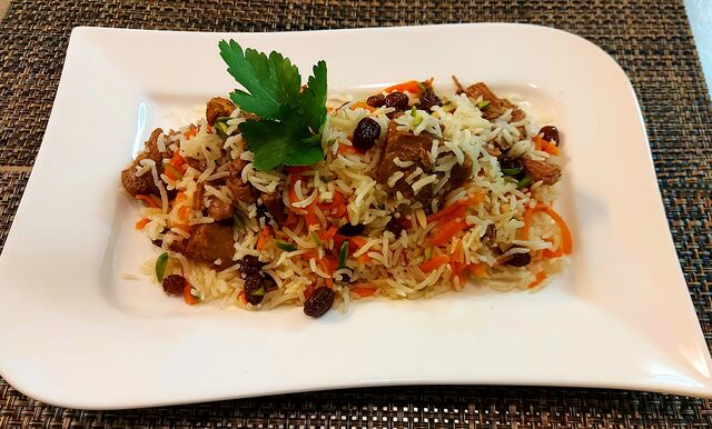 Geschmorte Lammkeule mit Basmatireis, Rosinen, gehackte Karotten, gesplitterte Mandeln und Pistazien 