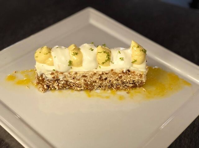 Cheesecake aux agrumes revissé par la Cheffe Agnès, sur gelée de pulpe d'orange, noisette caramélisées et noix de coco