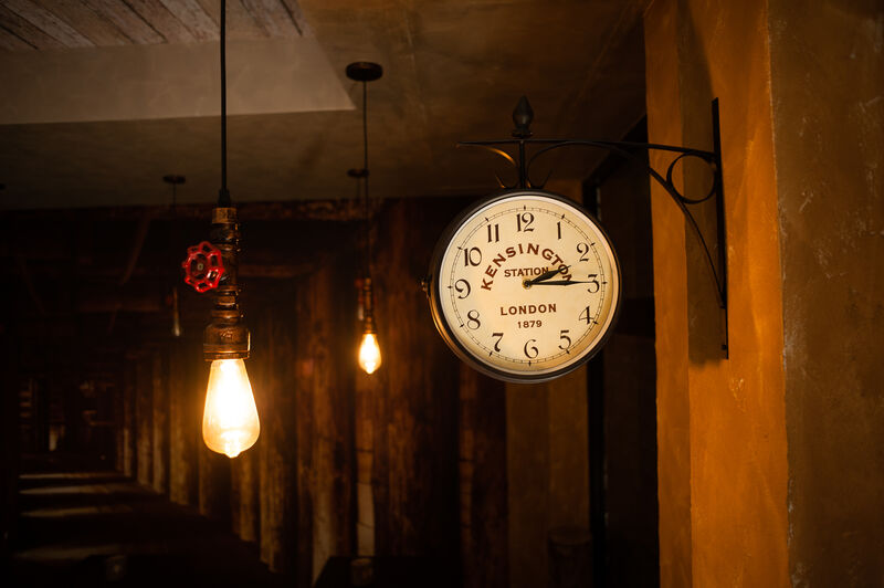 dettaglio orologio bifacciale antico con illuminazione originale, colori caldi ed accoglienti