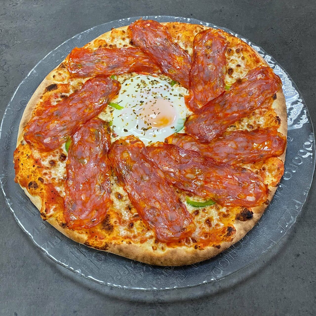 Pizza Spianata
Sur fond de tomate, Mozzarella, poivrons, oeuf, Spianata