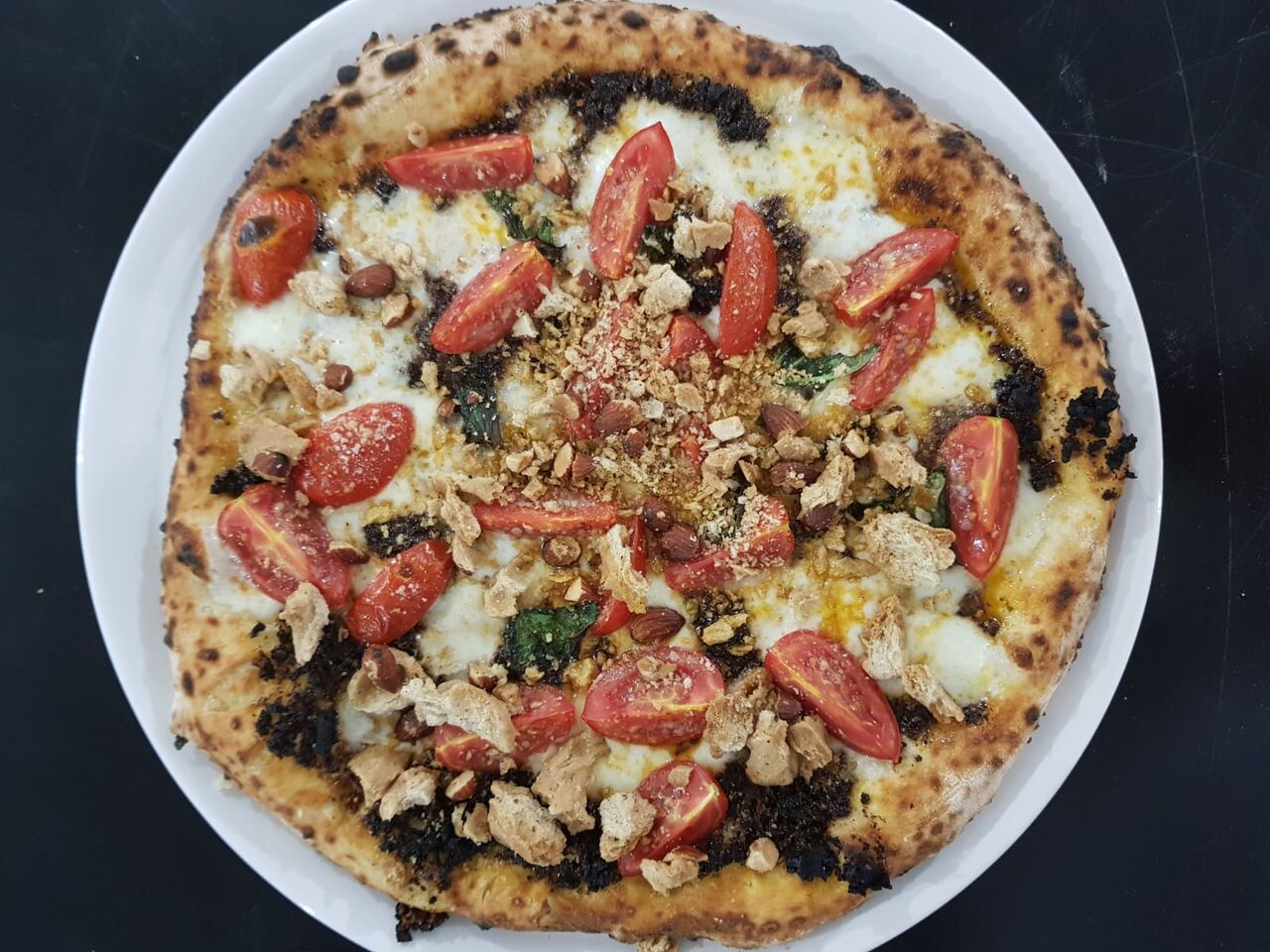 La pizza pomodorini mozzarella e taralli sugna e pepe sbriciolati