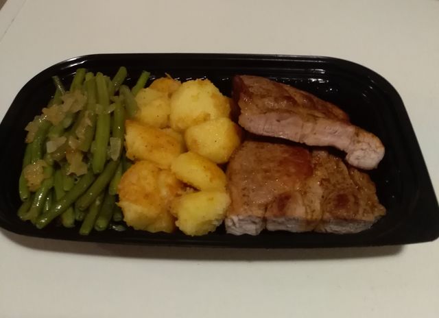 Varkenskotelet met boontjes en gebakken aardappel