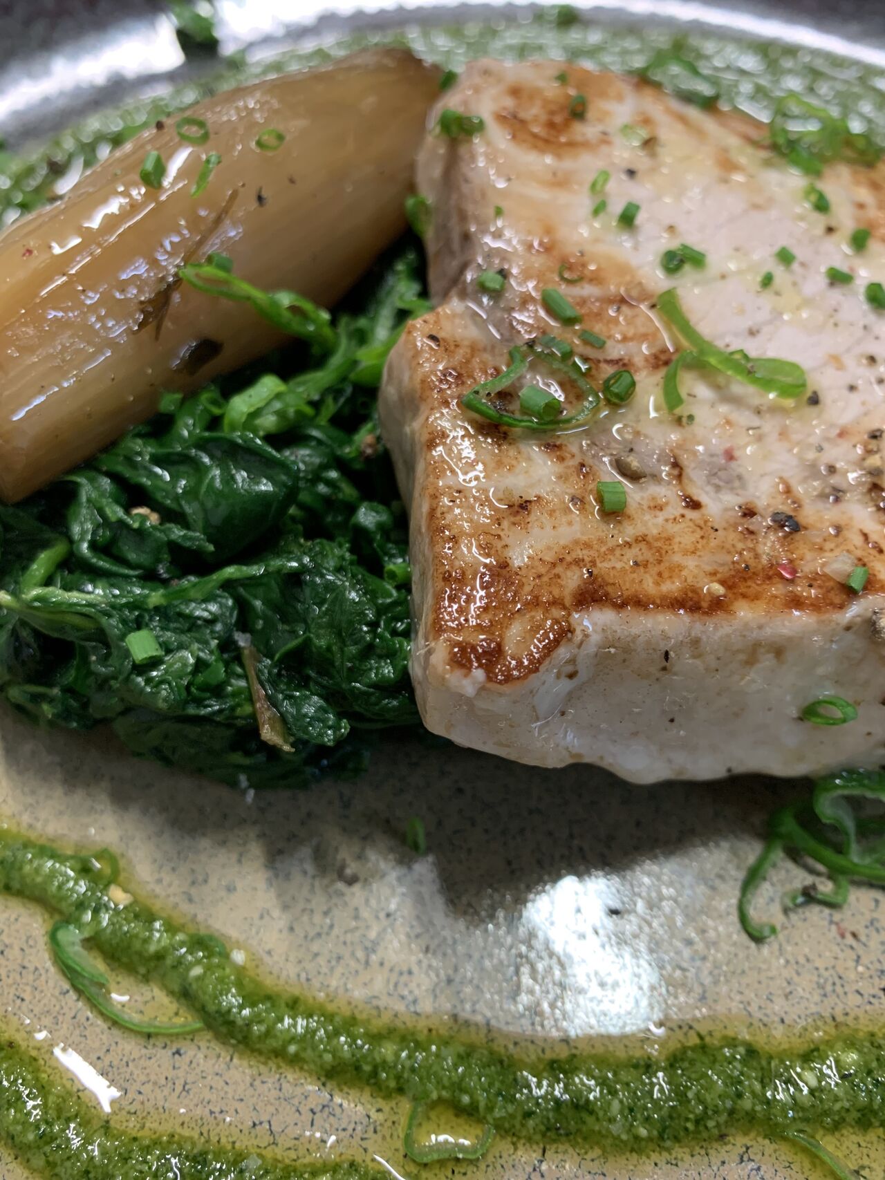 Le pavé d’Espadon à la Plancha, Echalotes Confites, Epinard et Pesto de Roquette
