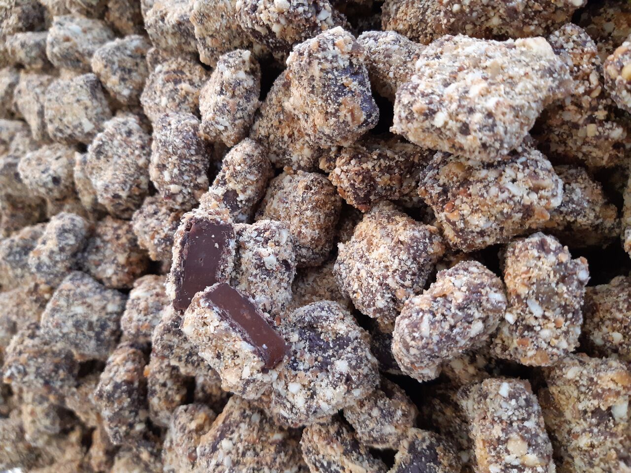 La spécialité: une ganache caramel enrobée d’une fine couche de chocolat noir et d'amandes/noisettes caramélisées