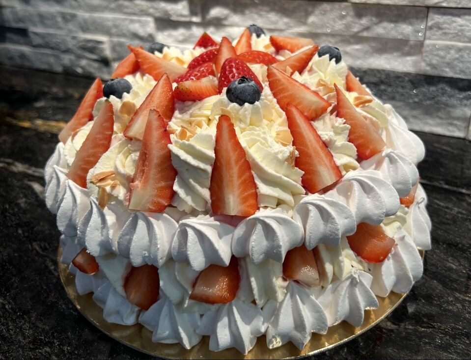 Gâteau Pavlova Fraises, Chantilly mascarpone vanille sur ses deux socles de meringue jonchées de ses fraises fraîches.