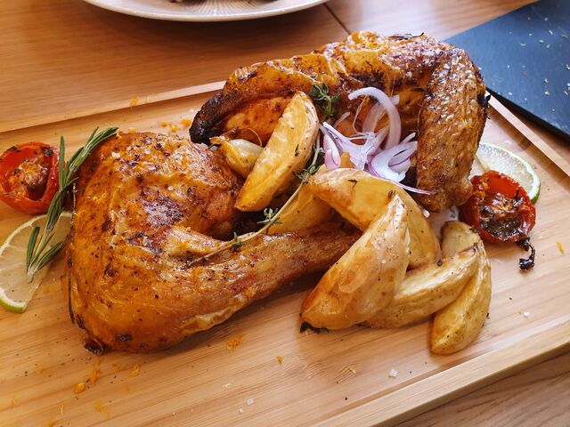 1/2 Pollo asado al horno con finas hierbas y toque ahumado, acompañado con patatas rústicas y salsa romesco