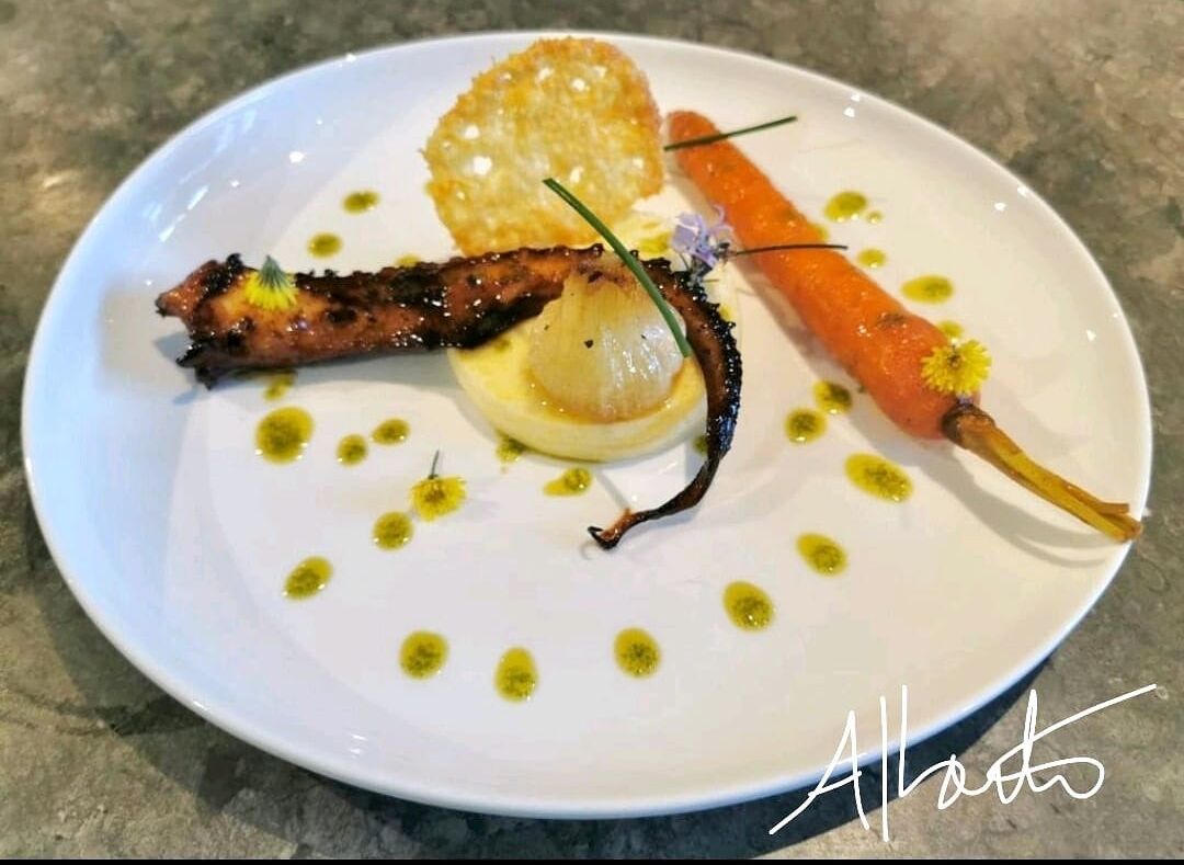 Tentacule de poulpe caramélisée accompagnée d'une polenta, oignon rôtie, carotte confite, tuile de parmesan.