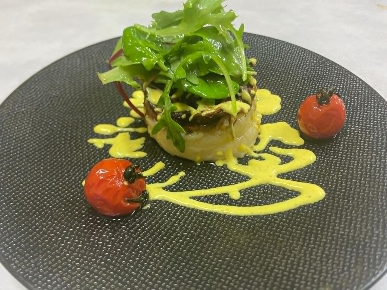 Emincé de confit de canard sur son écrasé de pommes de terre, sa sauce au curry et ses tomates confites