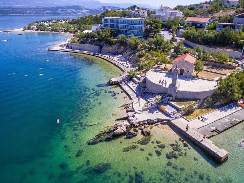 There is small lighthouse in front of church Saint Nicholas and hotel is in the back of the photo