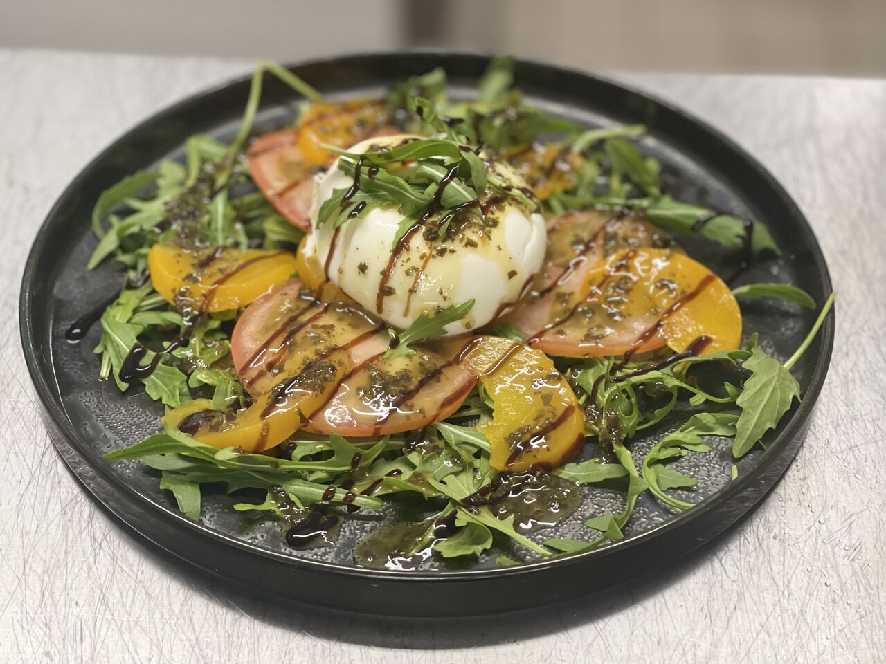 Tomate, pêche, burrata, roquette et crème de balsamique