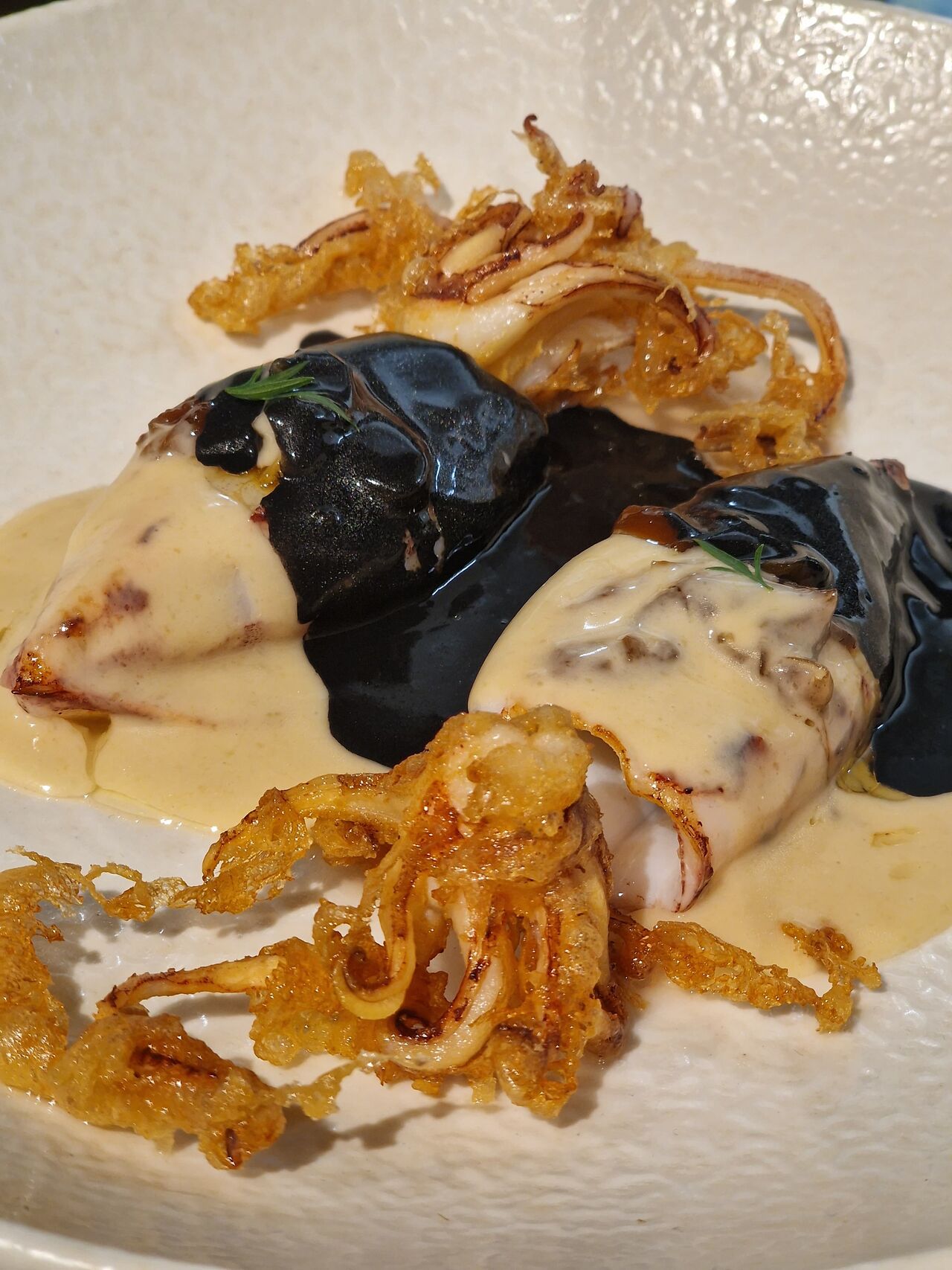 Chipirones frescos con salsa de parmesano y tinta de calamar