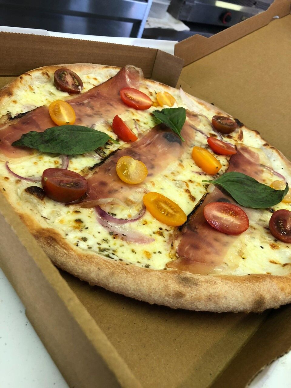 PIZZA: base crème, mozzarella, oignon rouge, speck de la vallée d'Aoste, tomates cerises et basilic frais