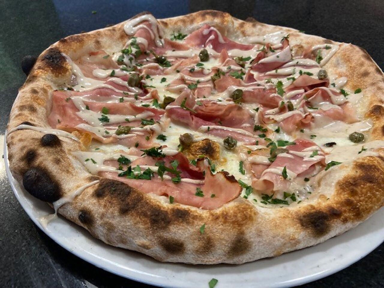Pizza Tonnina: Mozzarella, Prosciutto, Crema di Tonnata, Kapern (12,50€)