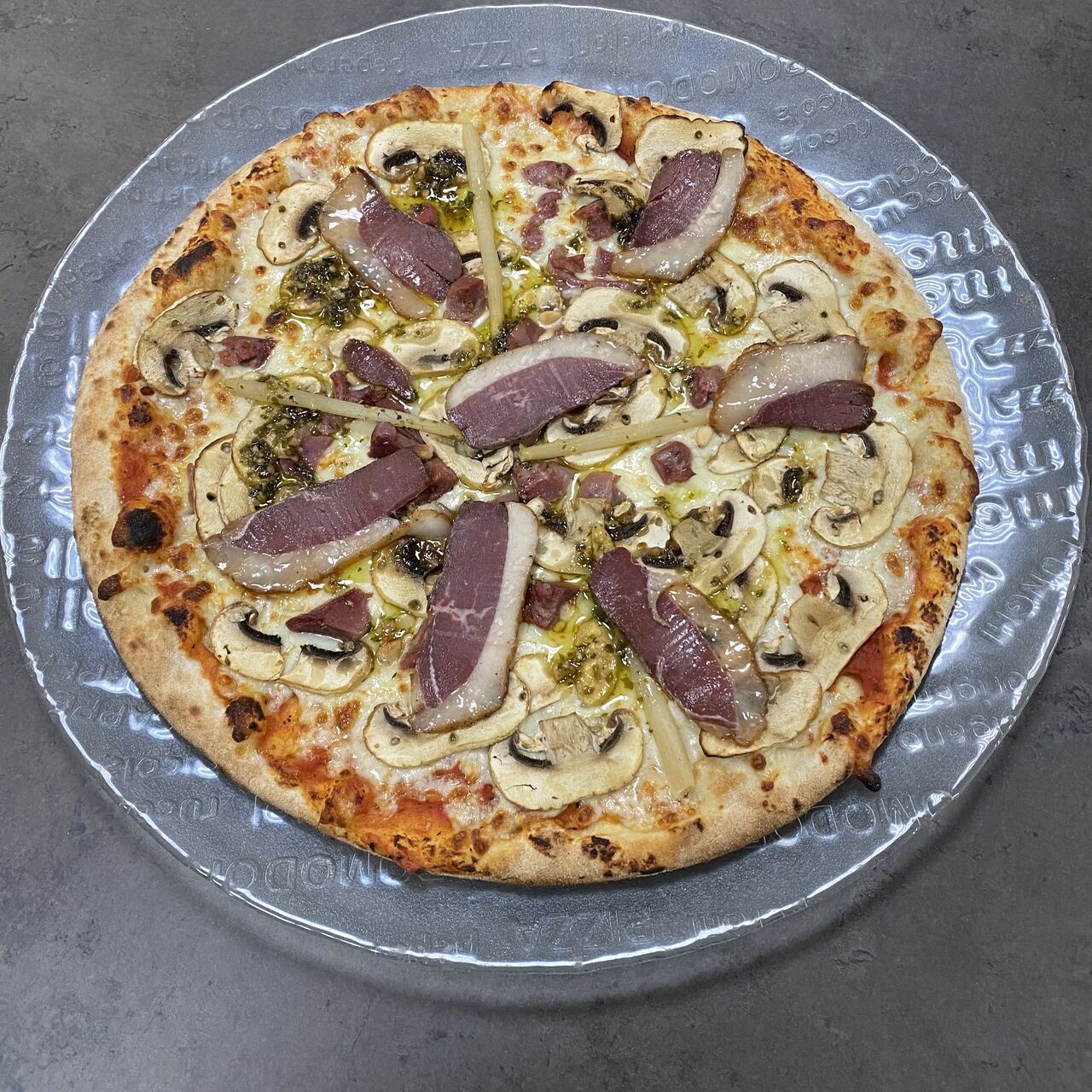 Pizza Landaise:
Tomate, mozzarella, gésiers de canard confits, champignons, pignons de pin, persillade, magret de canard séché