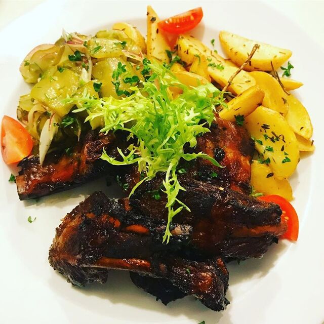 Żeberka z pieca w glazurze z nalewki wiśniowej. Podane z ziemniakami pieczonymi w ziołach i z surówką z kiszonego ogórka i czerw