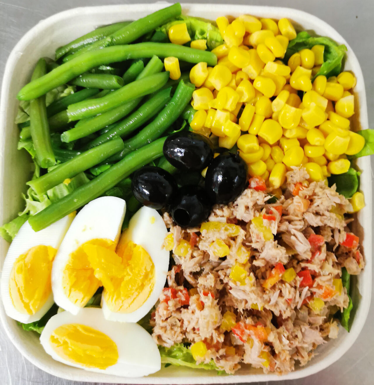 Salade au Thon:
Batavia, thon cuit, oignons, poivrons crus, haricots verts, œufs durs, olives noires, maïs.