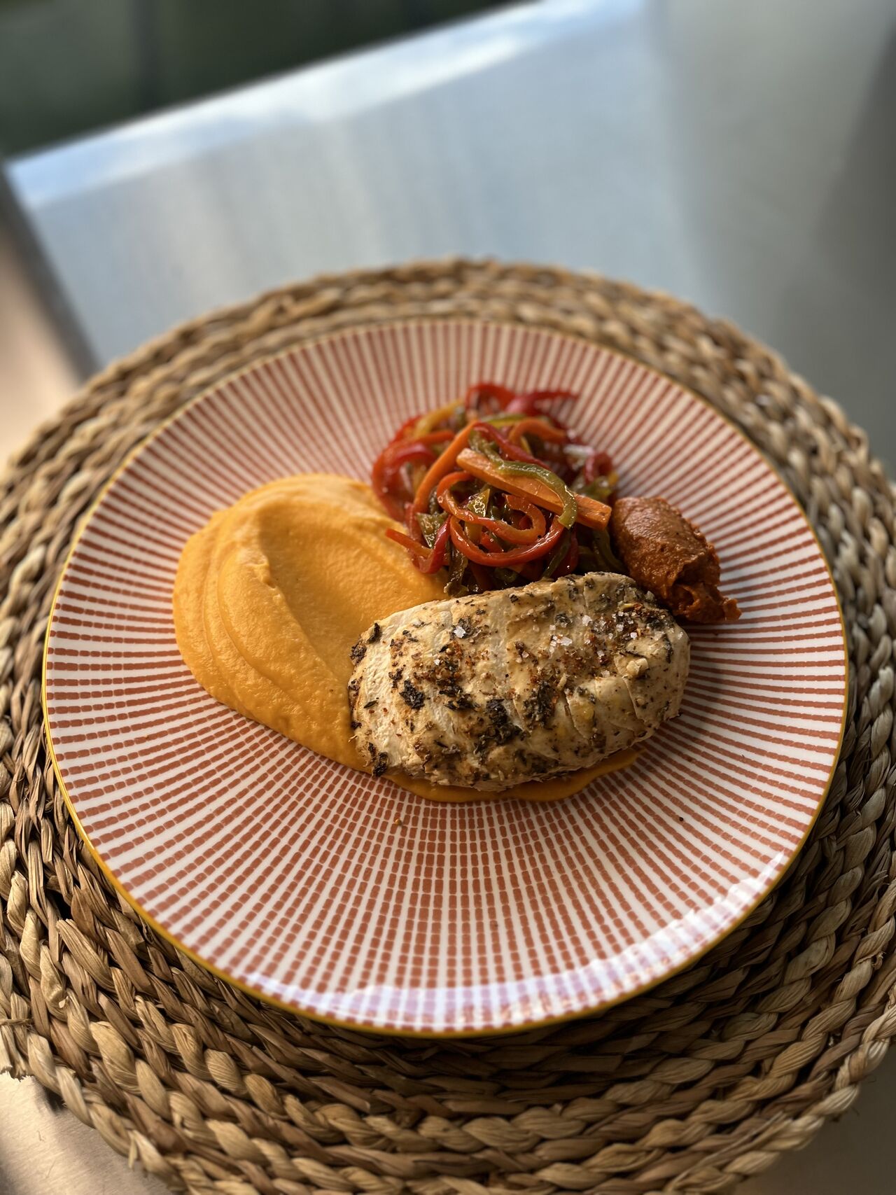 Suprême de poulet mariné aux épices Louisiana, mousseline de patates douces, poêlé de poivrons 