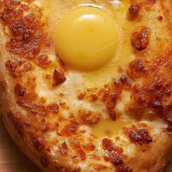 Хачапурі по-аджарськи із сиром сулугуні, імеретинським сиром та яйцем.