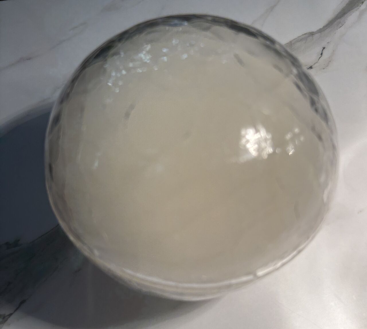 Bacalao con salsa kimchi de salmorejo canario envuelto en una esfera ahumada